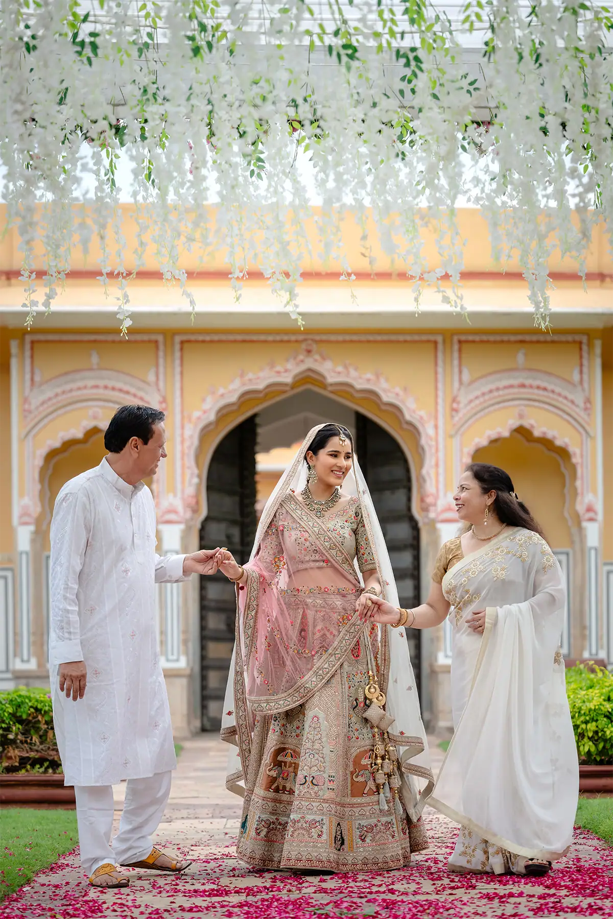 La novia camina junto a sus padres en un momento espontáneo y natural capturado en una foto de la boda.