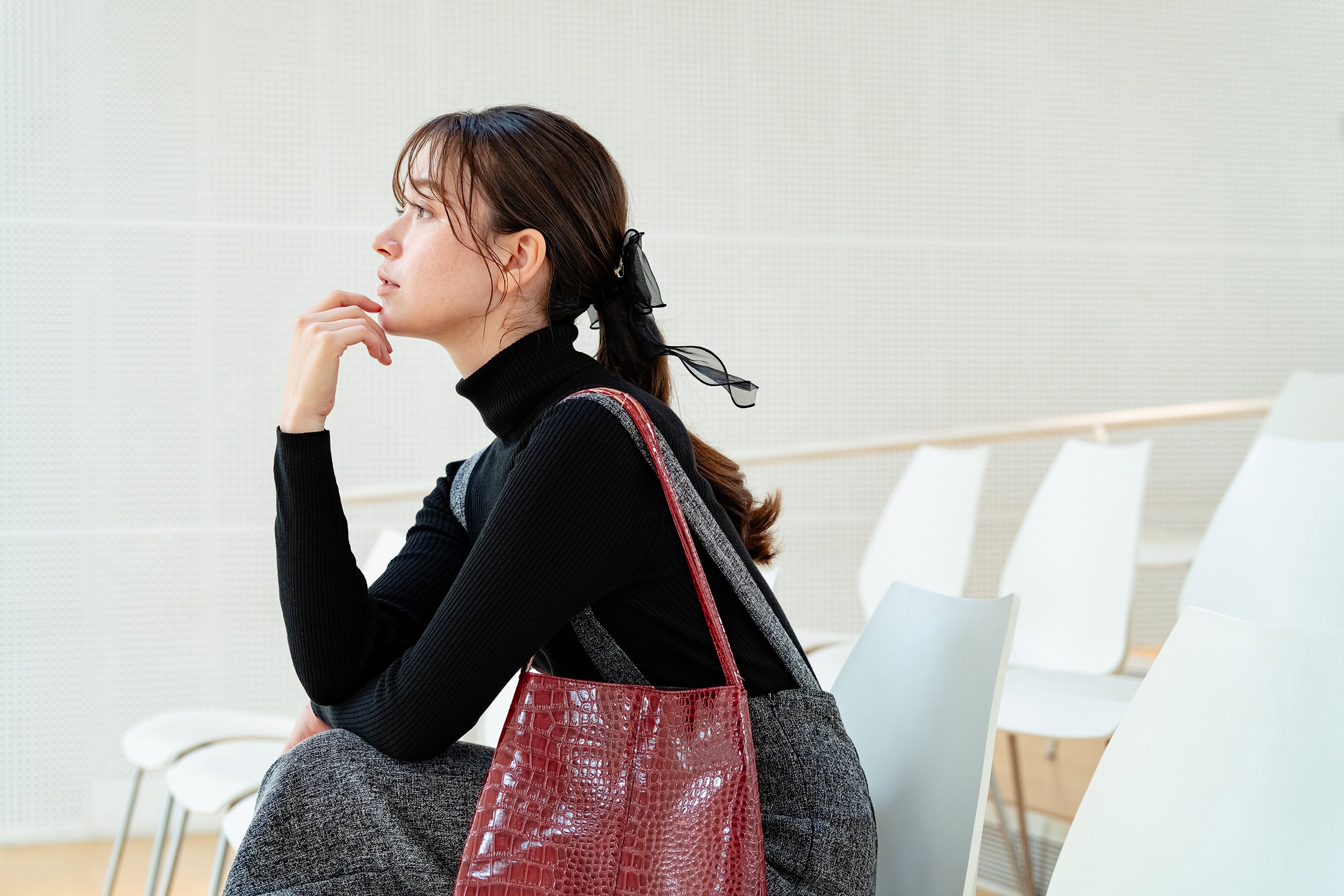 Mujer sentada en el interior en un retrato espontáneo y natural, con expresión pensativa