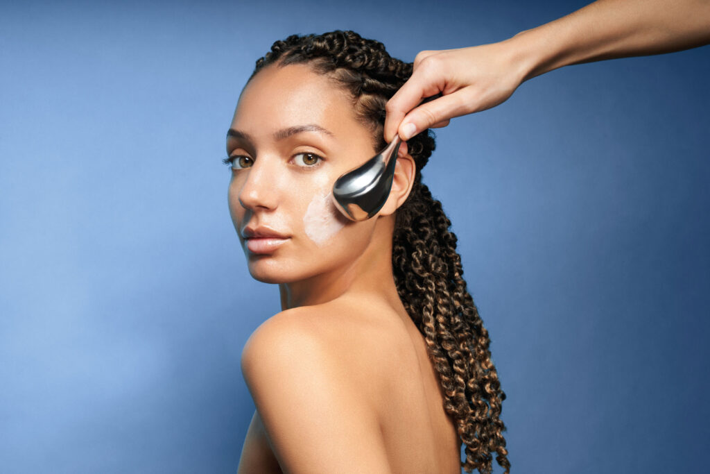 Woman receiving a facial massage with a facial roller at Tonic Day Spa, promoting skin relaxation an.