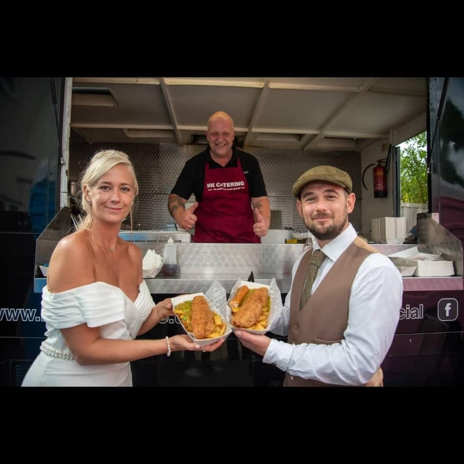 Fresh fish and chips from KK Catering food truck in the UK, served at an outdoor event with happy customers.
