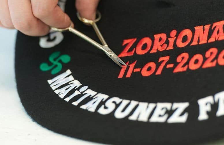 limpieza-hilos-txapela-bordada-con-tijera