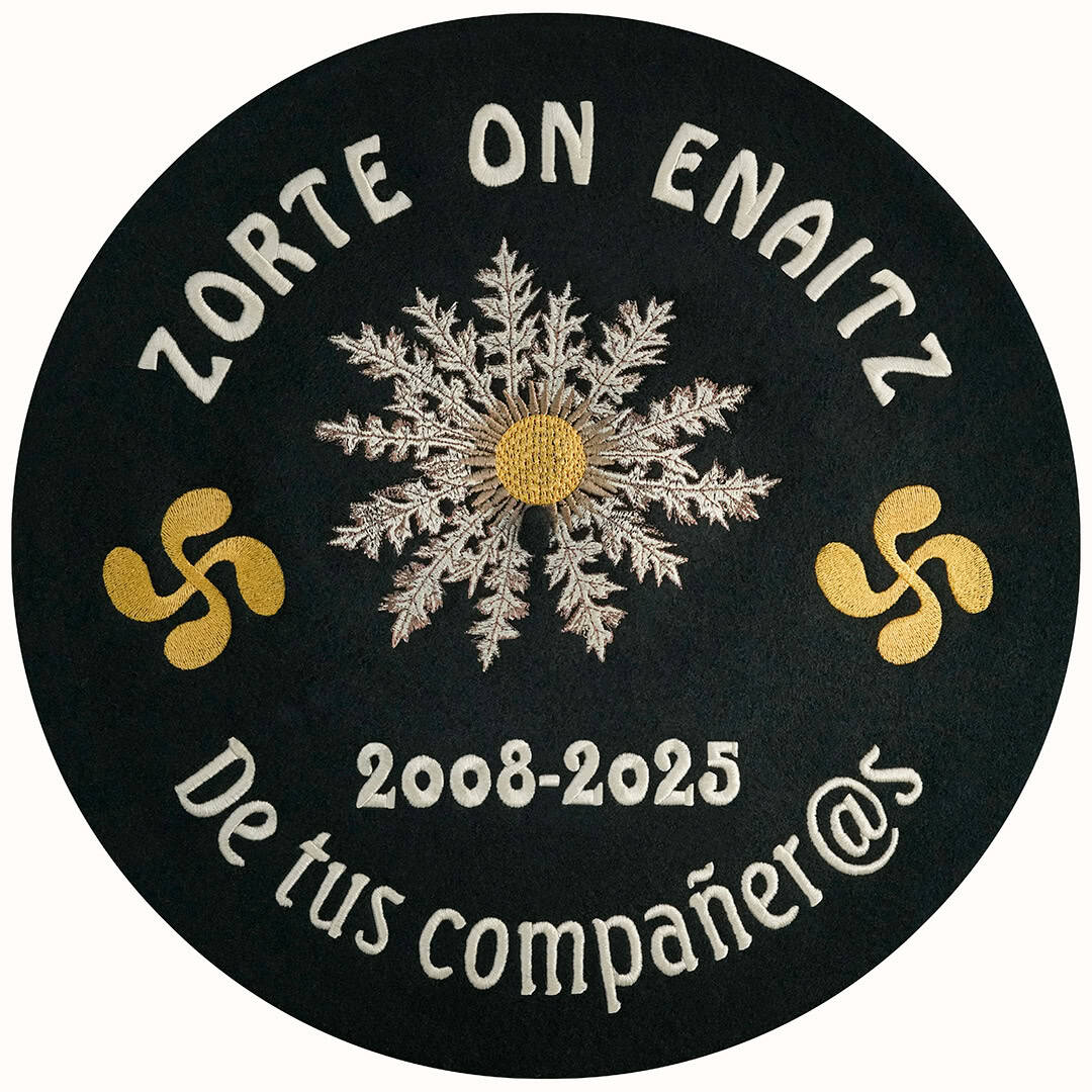 Txapela personalizada para despedida de un compañero de trabajo con bordados de eguzkilore y lauburus, fechas, nombres y frases con hilo color oro y beige