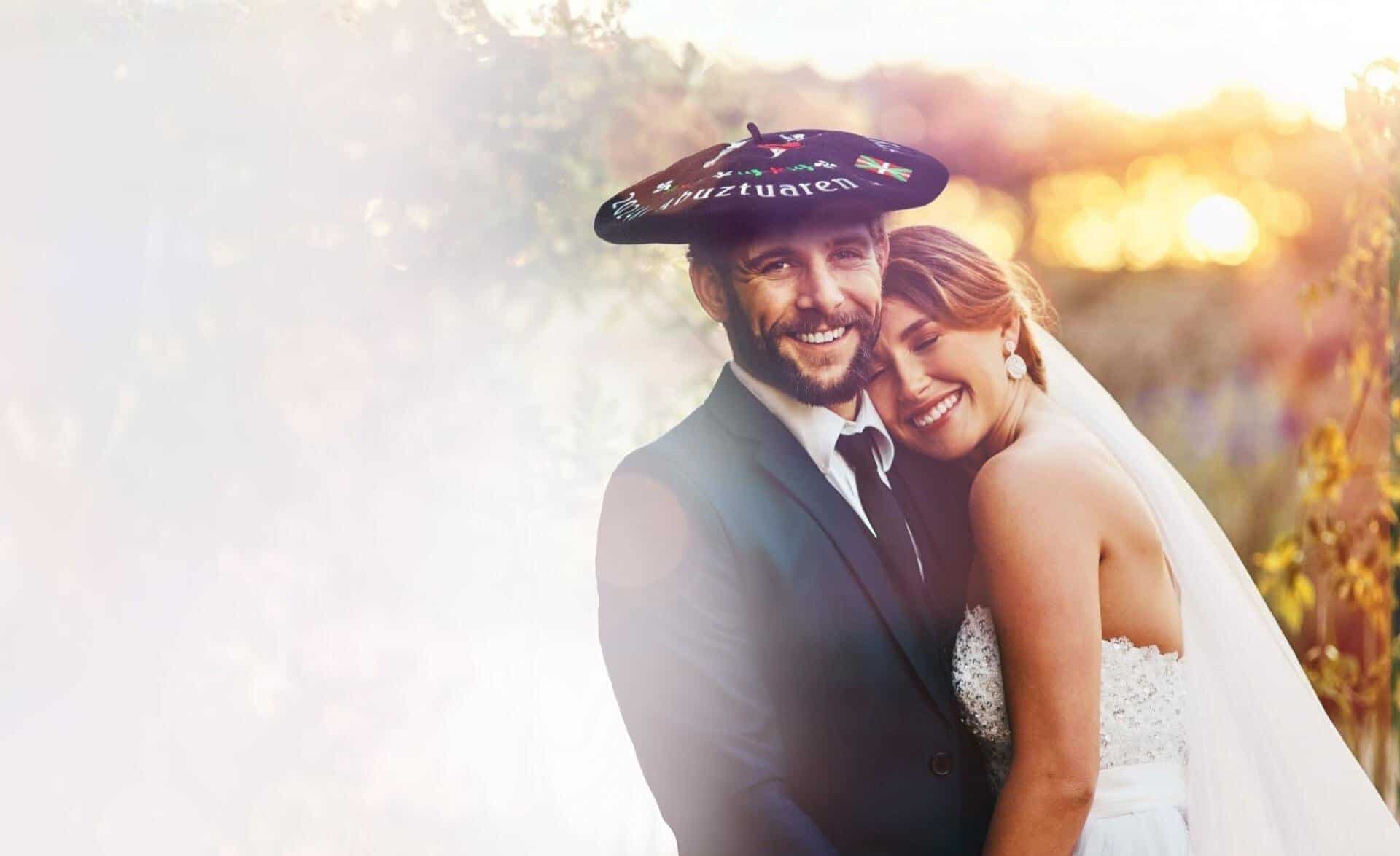 novio con txapela para boda abrazado a su novia