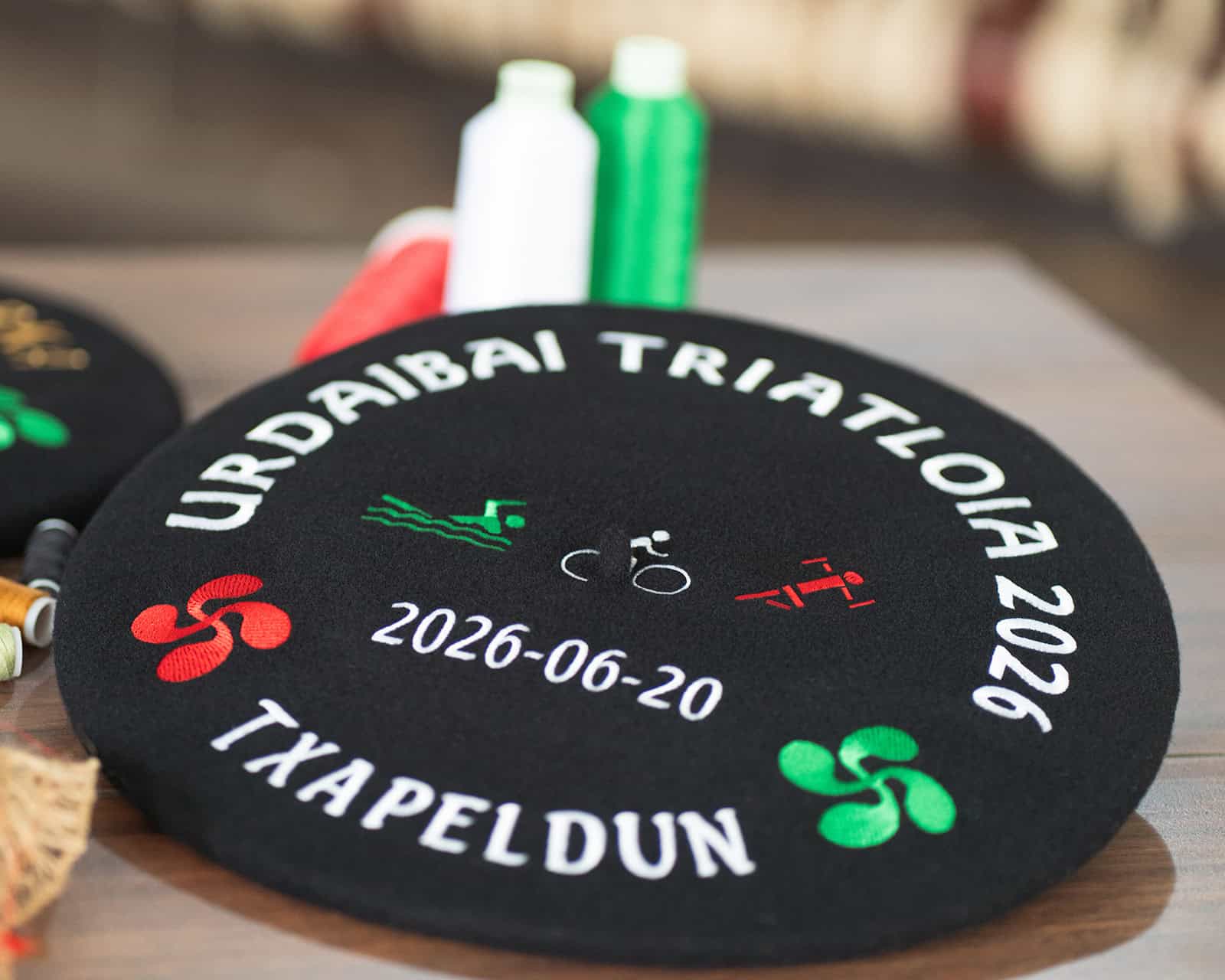 Txapela bordada personalizada para el urdaibai triatloia en colores verde rojo y blanco