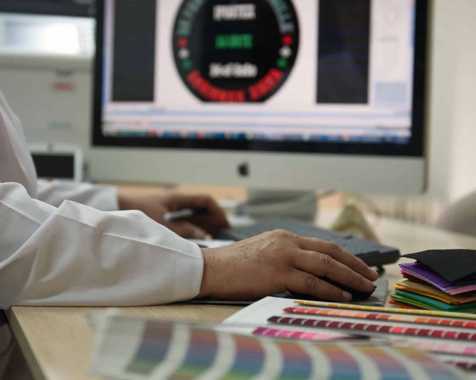 Proceso de diseño y digitalización de una txapela personalizada en el taller de Teletxapela, con carta de colores y muestras de paño.