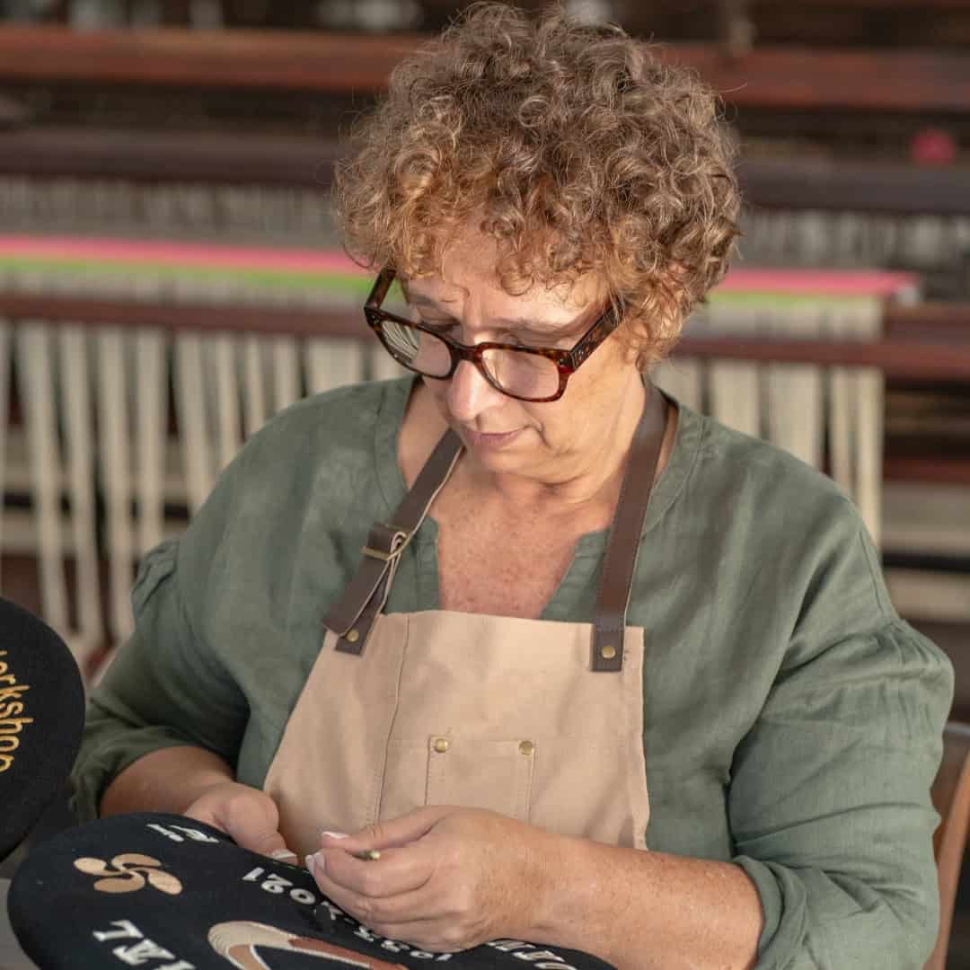 Valeria revisando una txapela personalizada en el taller de Teletxapela