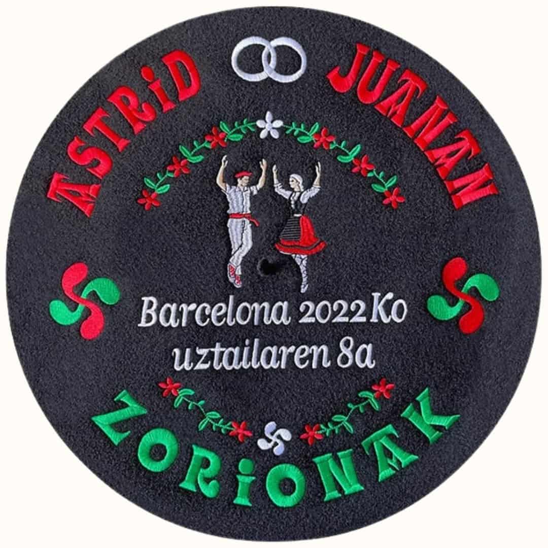 Txapela personalizada para boda con bordados de dantzaris, alianzas, lauburus, nombres, lugar y fecha