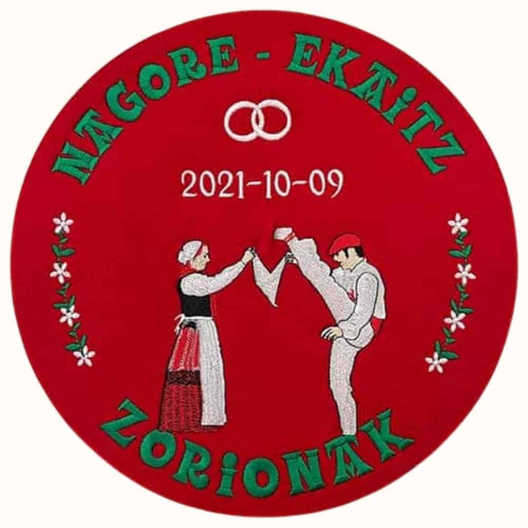 Txapela roja bordada para boda con aurreskulari, lazo de flores, alianzas, fecha y nombres