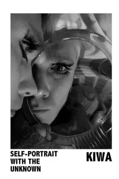 Black and white self-portrait of a woman looking into a mirror.
