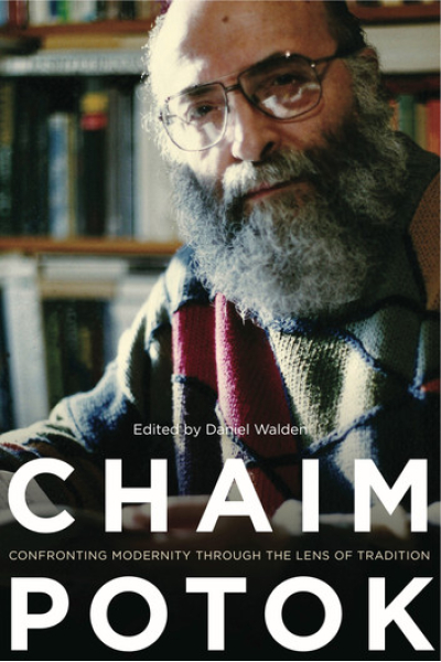 Close-up of Chaim Potok with glasses and beard, bookshelf background.