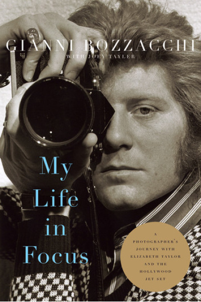 Portrait of Gianni Bozzacchi holding a camera, black and white photo.