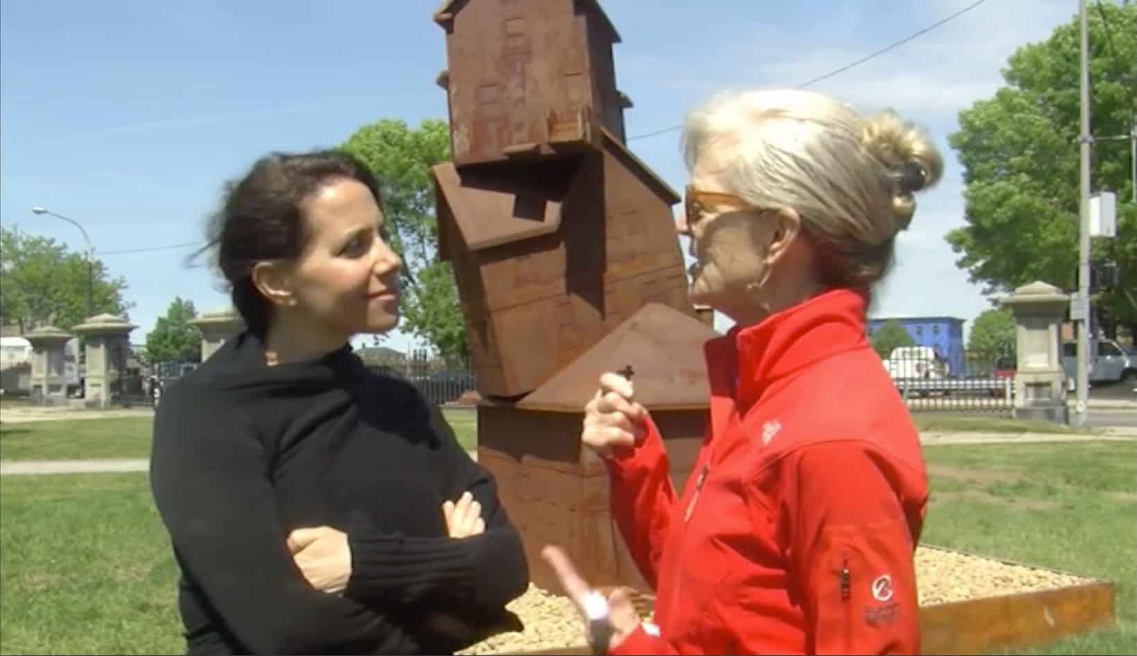 Two women discussing a contemporary outdoor sculpture at TEMPOart event.