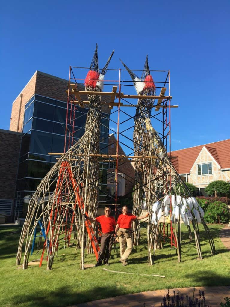 Impressive bamboo sculptures of giraffes being built with scaffolding in an outdoor setting.