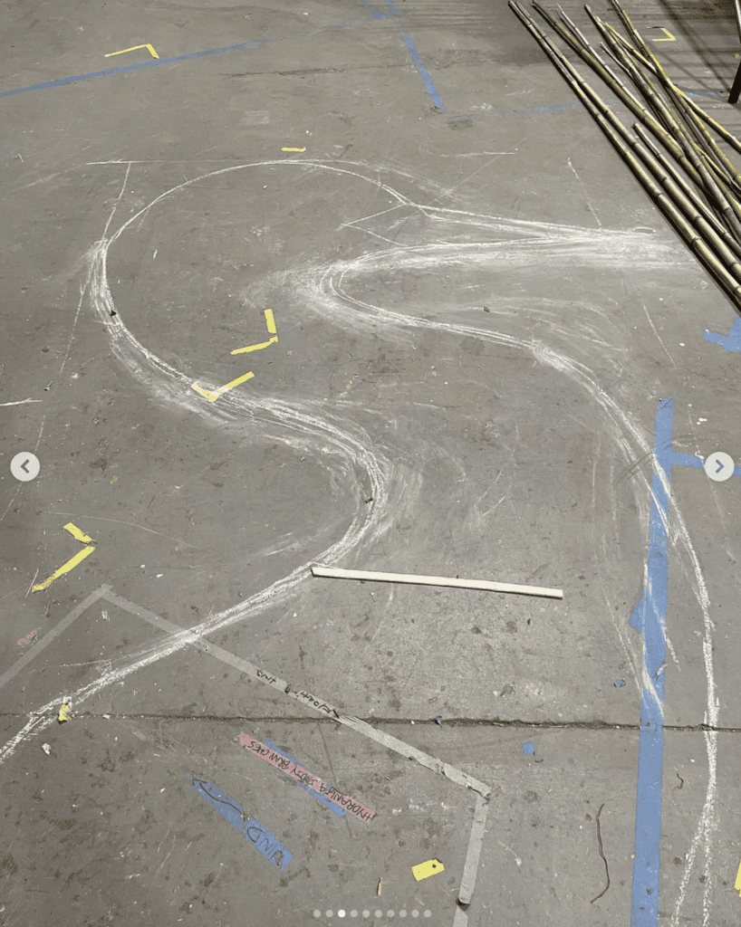 Chalk drawing of a winding dance floor on concrete for "Dancing for Joy" art piece.