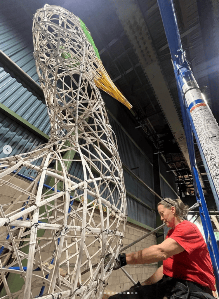 Sculptor working on the large "Dancing for Joy" wireframe art piece.