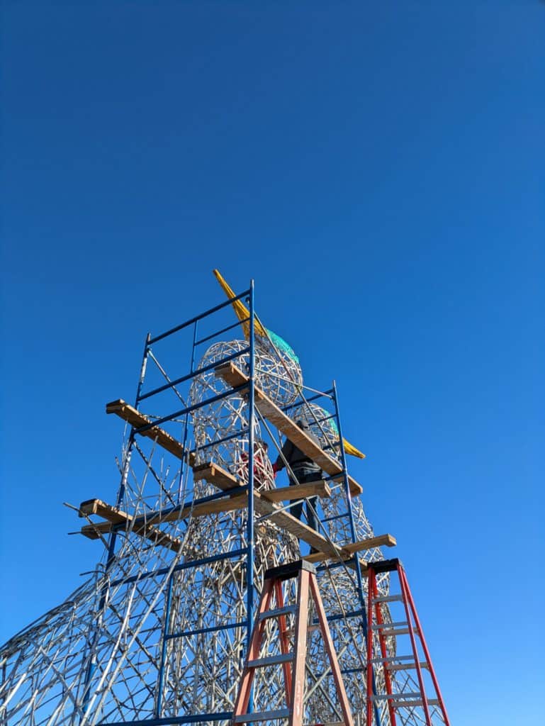 Artistic metal tower sculpture for public art displays under clear blue sky.