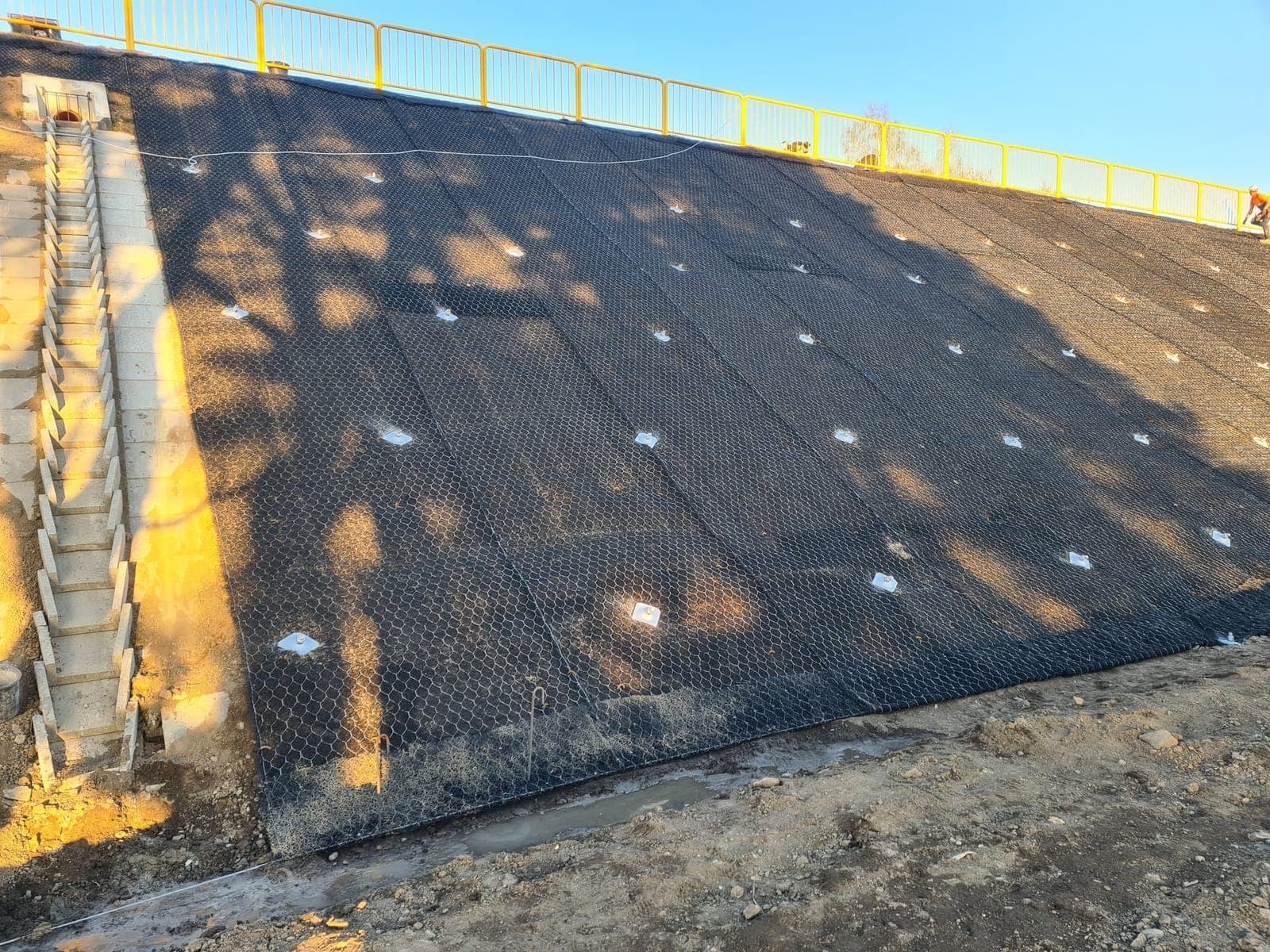Zabezpieczanie skarpy siatką stalową — widok z boku