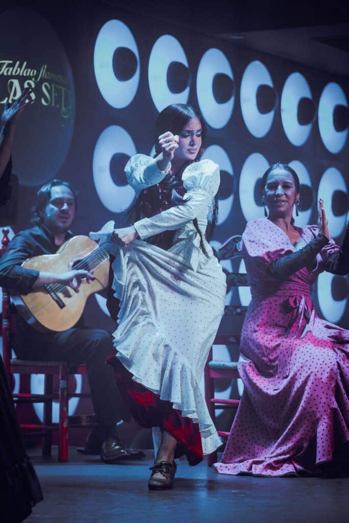 Traje de flamenca rojo con volantes en tablao sevillano