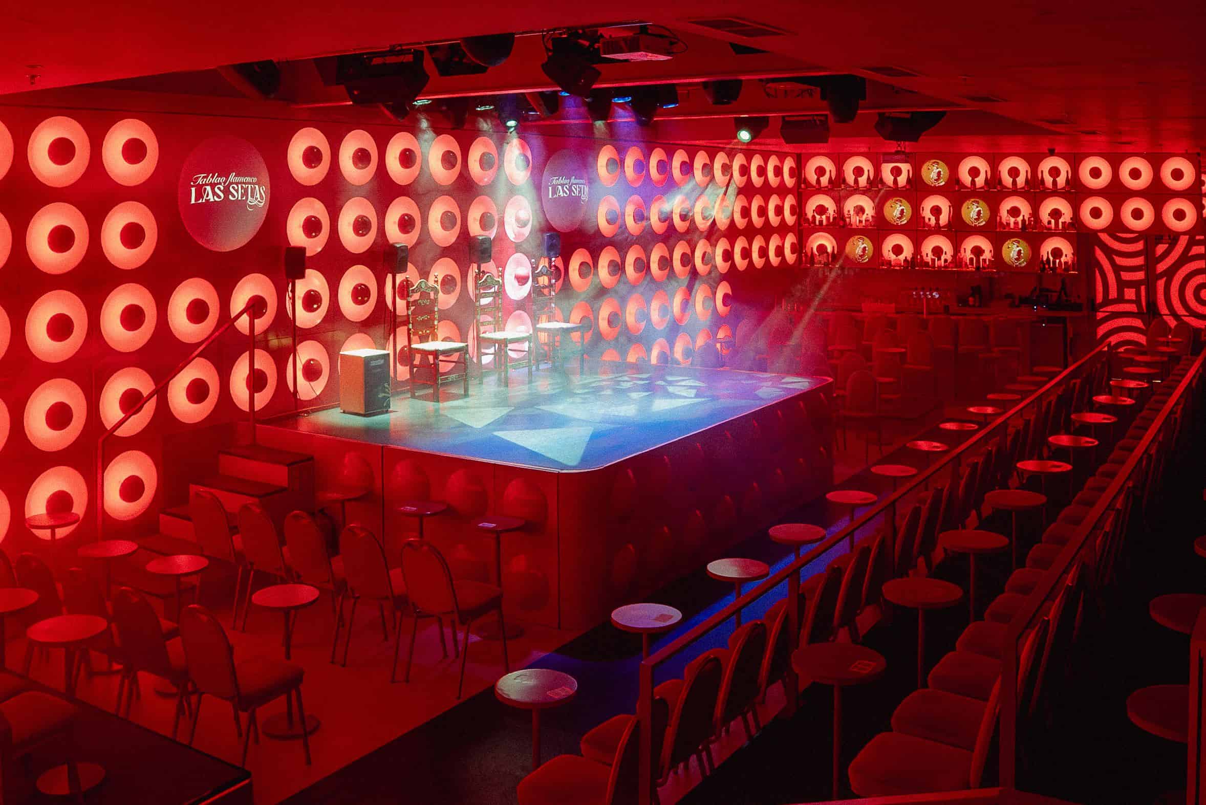 Interior del Tablao Flamenco Las Setas en Sevilla: escenario iluminado con artistas flamencos, asientos elegantes con vista cercana al espectáculo, diseño moderno bajo el Metropol Parasol