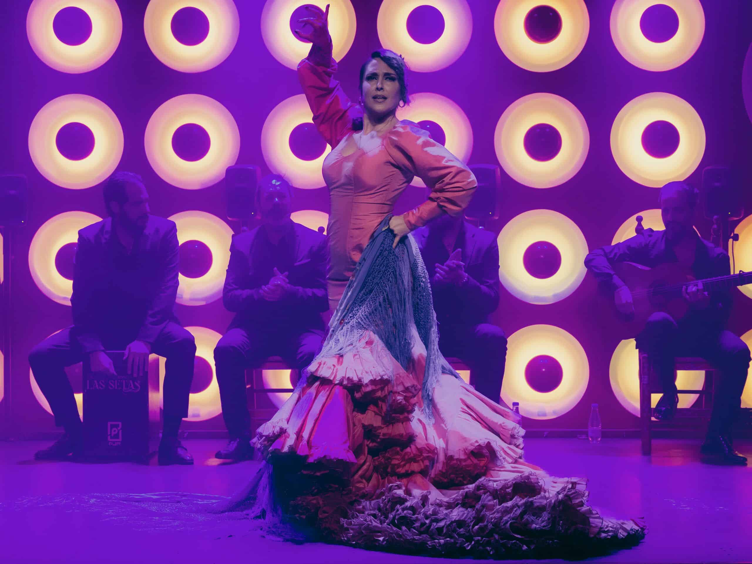 Bailaora flamenca en el escenario con músicos al fondo en Tablao Flamenco Las Setas, Sevilla