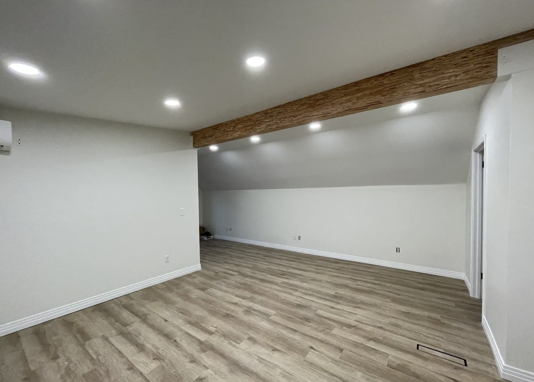 Interior view of a newly finished room with modern flooring and lighting.
