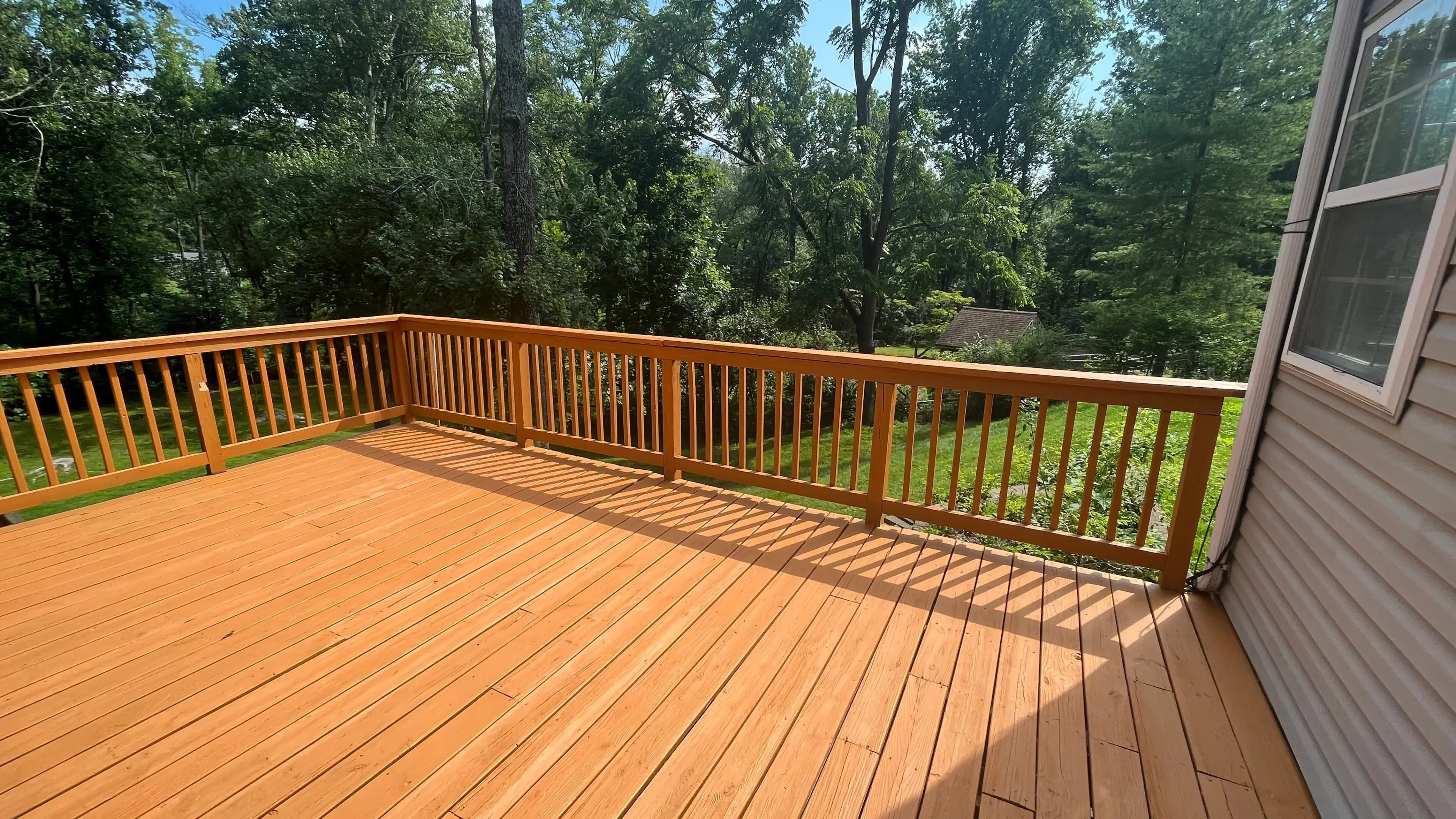 Beautiful wooden deck with railing, perfect for outdoor living and entertaining.