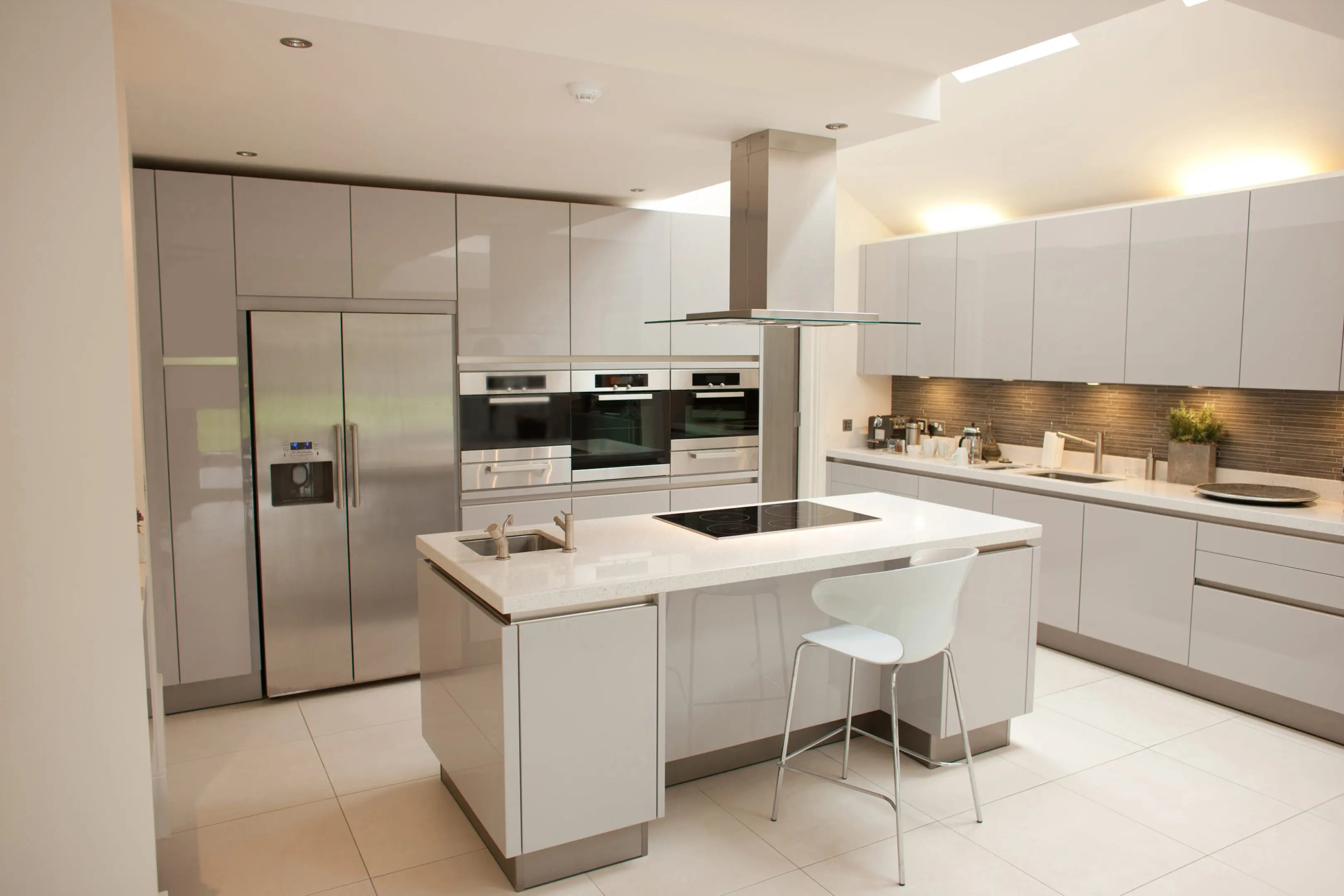Kitchen with white cabinetry, stainless steel refrigerator, and a central island.