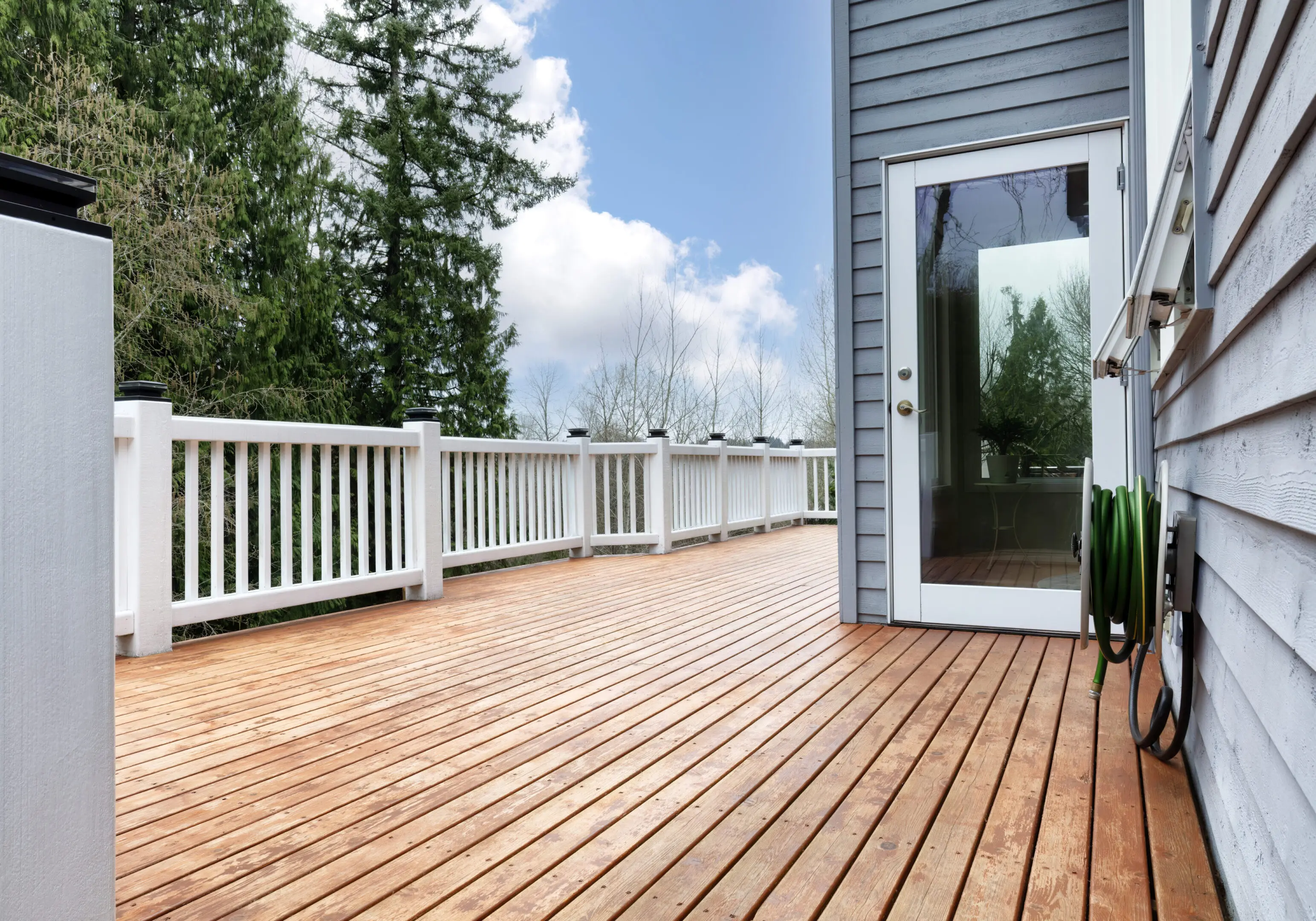 Outdoor wooden deck with railing, ideal for entertaining and relaxing in a backyard setting.