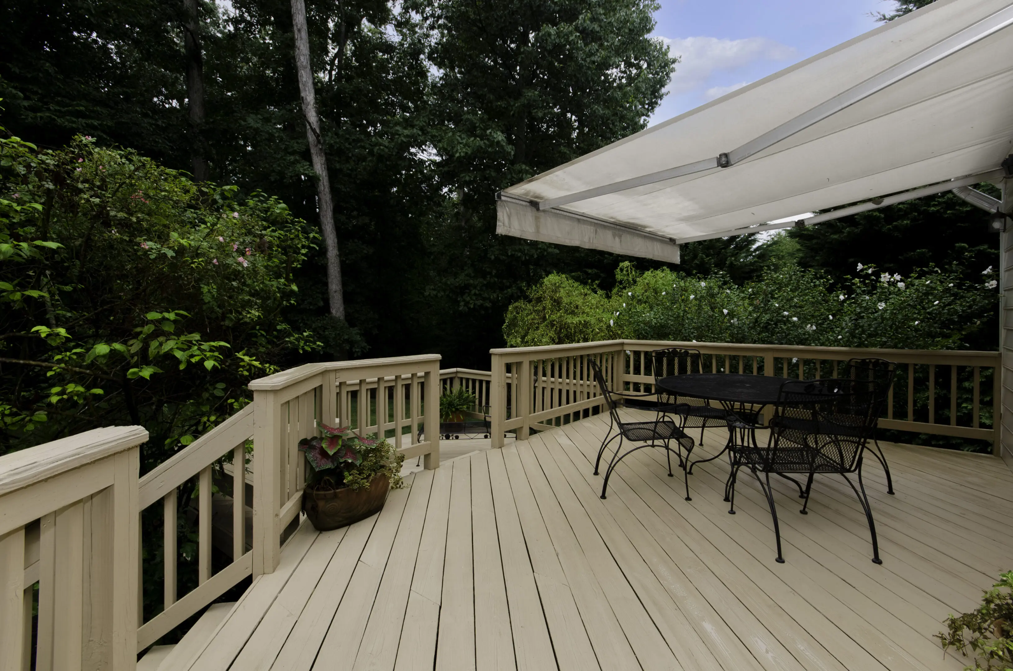 Beautiful wooden deck with outdoor furniture and shade for leisure activities.