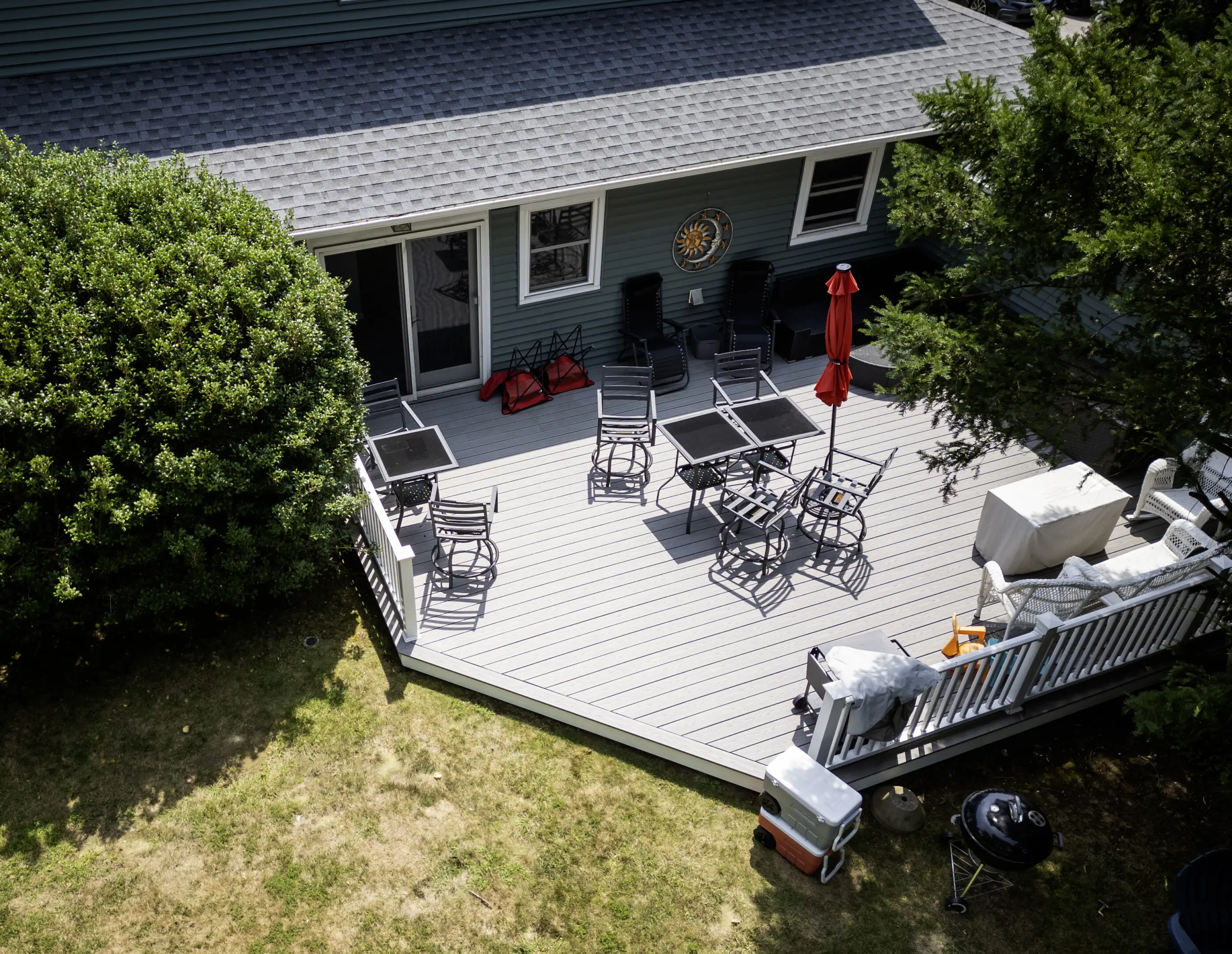 Beautiful backyard deck with seating area, umbrella, and surrounding greenery.