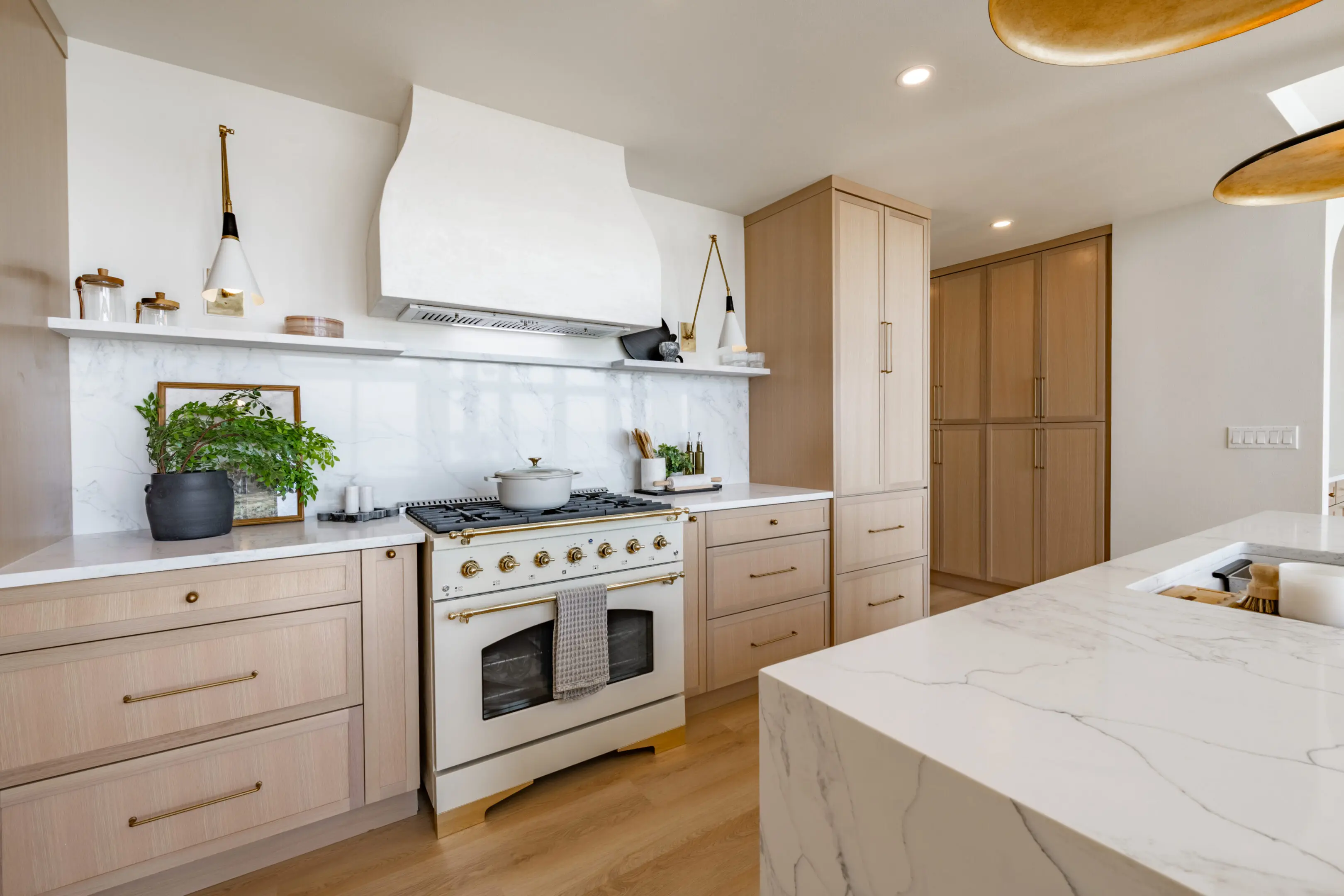 Beautiful kitchen featuring light wood cabinetry and a sleek marble island for cooking and entertain.