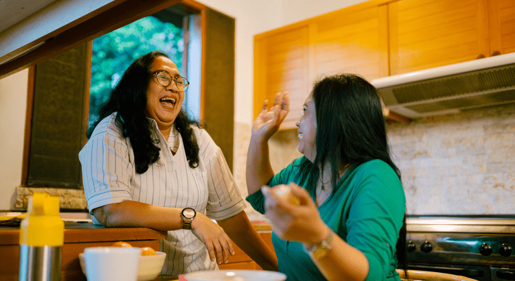 Friendly real estate agents laughing together in a cozy kitchen.