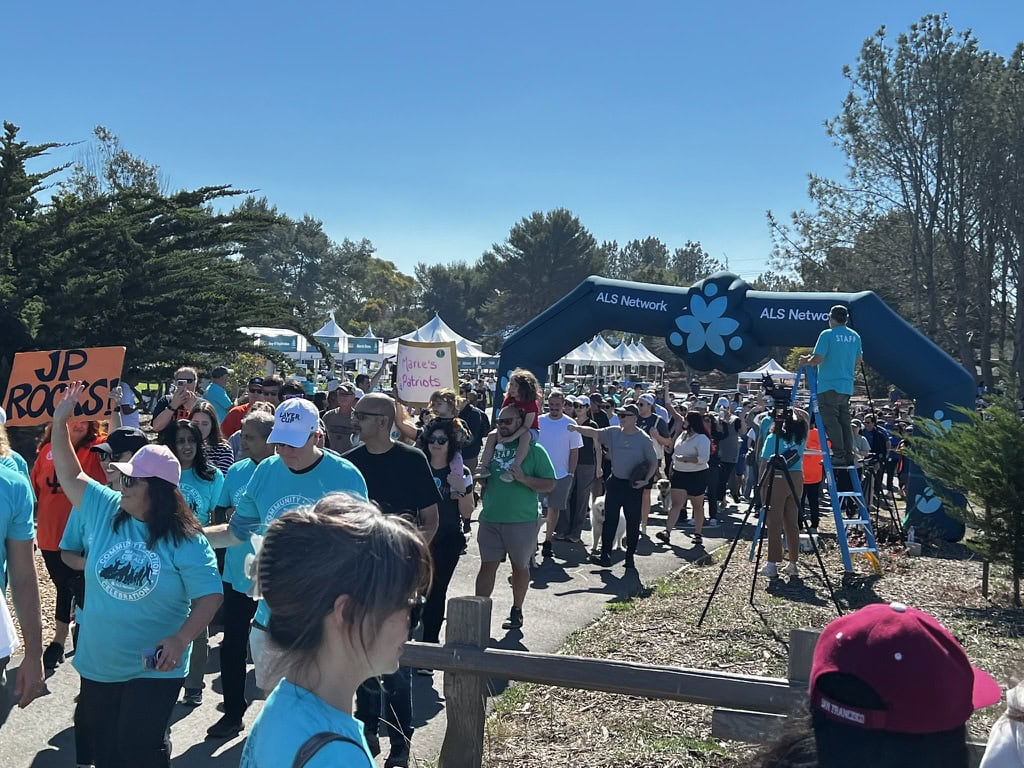 Crowd gathered at ALS Walk event in Walnut Creek, CA, with team members and supporters under a bright blue sky.