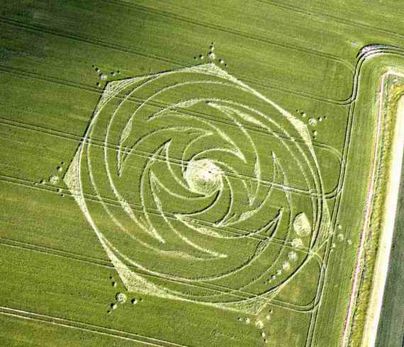 Crop circle pattern in a lush green field, showcasing intricate geometric design.