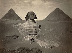 Sphinx and pyramids of Giza under a cloudy sky, showcasing Egypt's historic monuments.