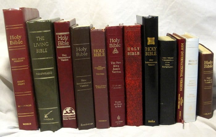 Collection of Holy Bible editions on a shelf for religious study.