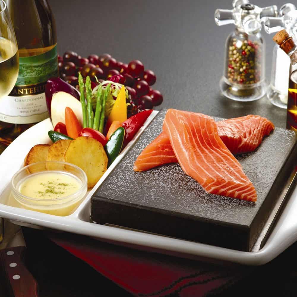 Fresh salmon steak with vegetables, potatoes, and creamy sauce at The Flames Galore restaurant.