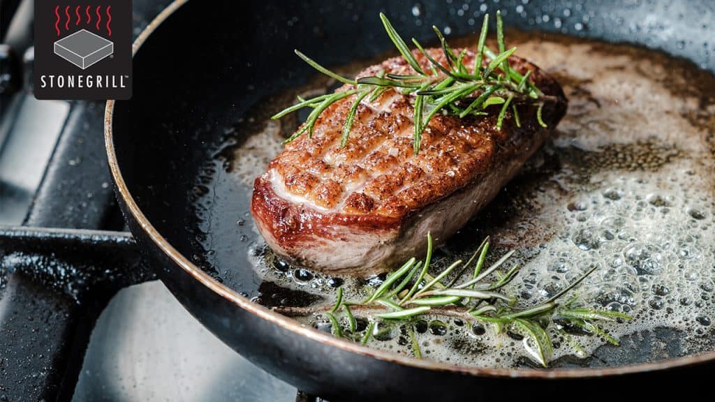 Juicy steak sizzling in a skillet with fresh rosemary, perfect for The Flames Galore restaurant.