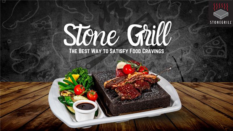 Juicy grilled steaks served on a stone grill with fresh vegetables and dipping sauce at The Flames Galore Restaurant.