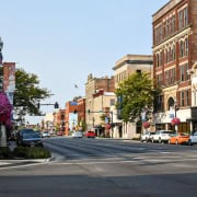 Colorful downtown Fostoria street with historic architecture and blooming floral displays, showcasing local community charm.