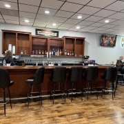 Bar area with TV screens, drinks, and seating at The Fostoria Free Press.