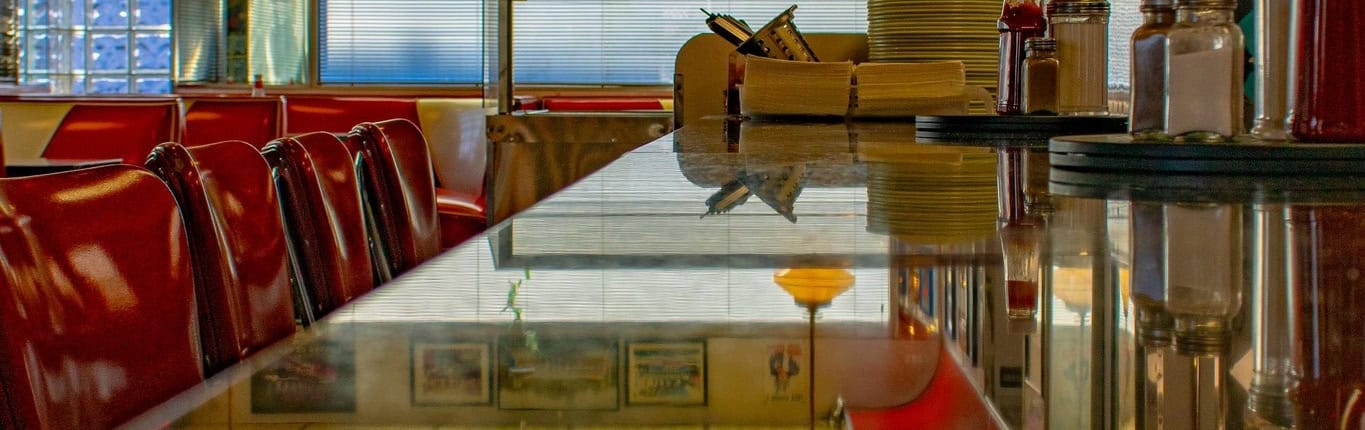 Bright, inviting diner atmosphere with red seating and decorative elements.