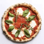Delicious Margherita pizza topped with basil leaves, mozzarella, and fresh tomato sauce, ideal for food lovers.