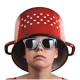Young person wearing a colander as a hat with sunglasses, symbolizing Fostoria local news coverage.
