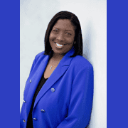 Professional woman in blue blazer smiling confidently.