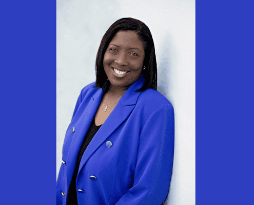 Professional woman in blue blazer smiling confidently.