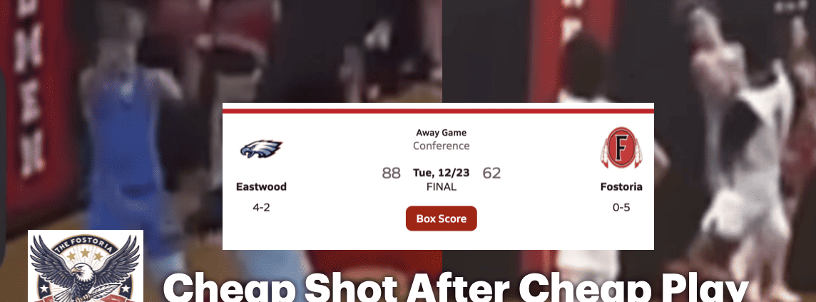 Crowd watches intense basketball game at Fostoria High School gymnasium.