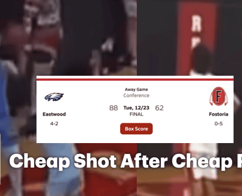 Crowd watches intense basketball game at Fostoria High School gymnasium.