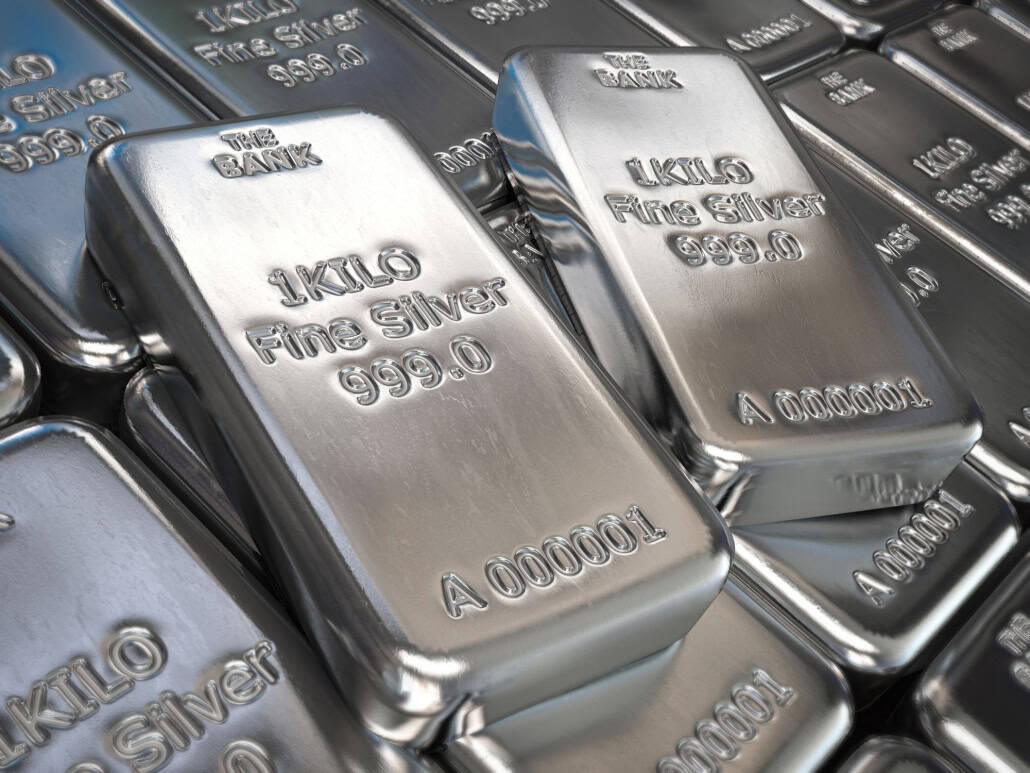Shiny silver silver bars with inscriptions, stacked closely together.