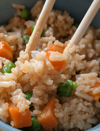 A bowl of steaming hot gluten-free vegan Instant Pot fried rice with colorful vegetables.